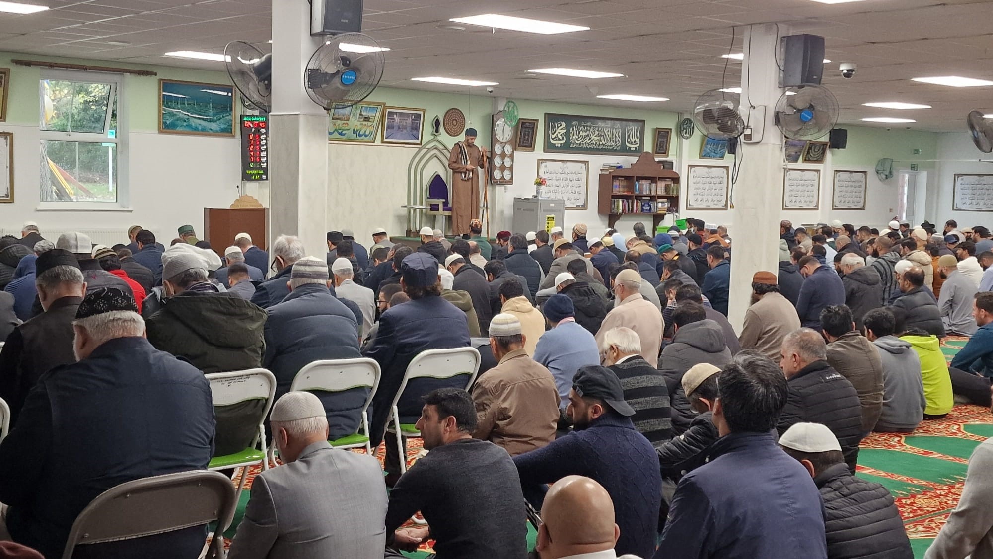 A group of men and boys listen to their imam in the Mosque